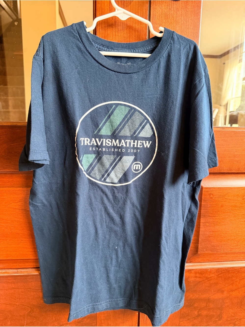 Travis Mathew Navy Short Sleeve Tee with Striped Circle Logo